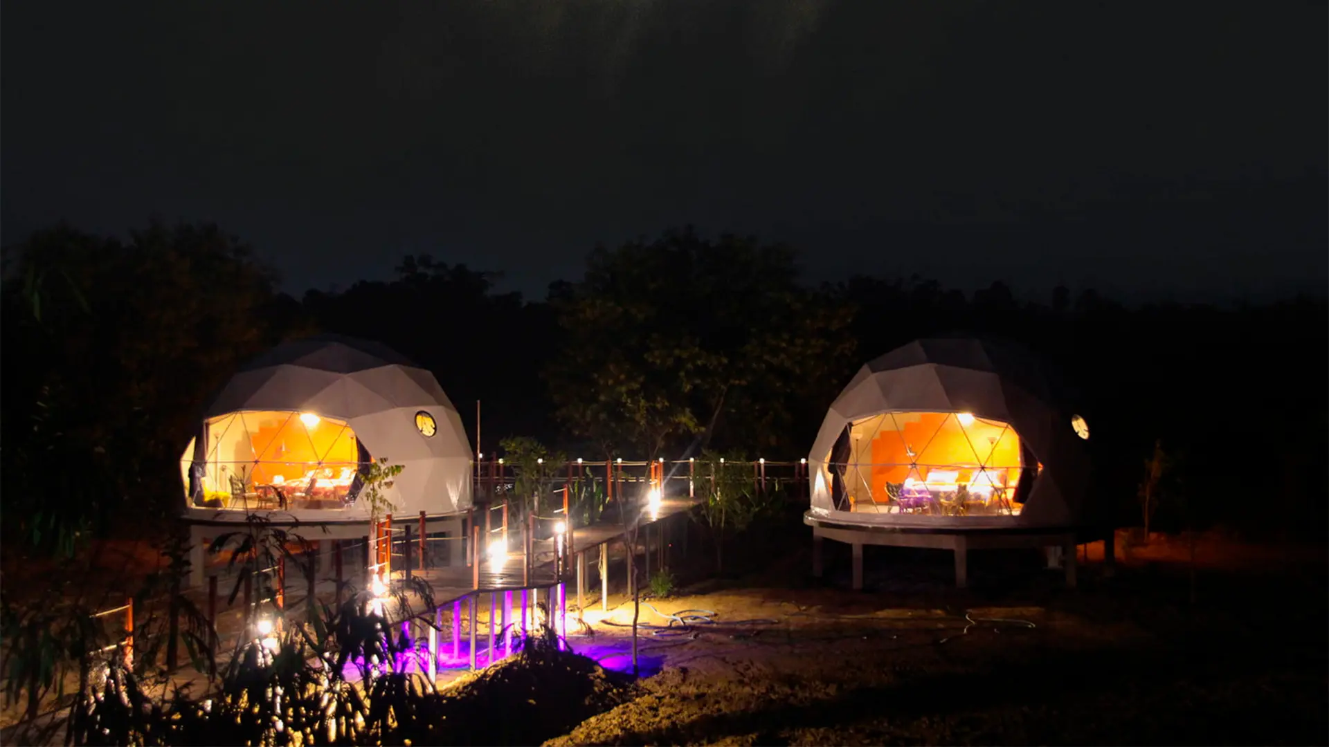 Domo geodésico junto a un lago al atardecer